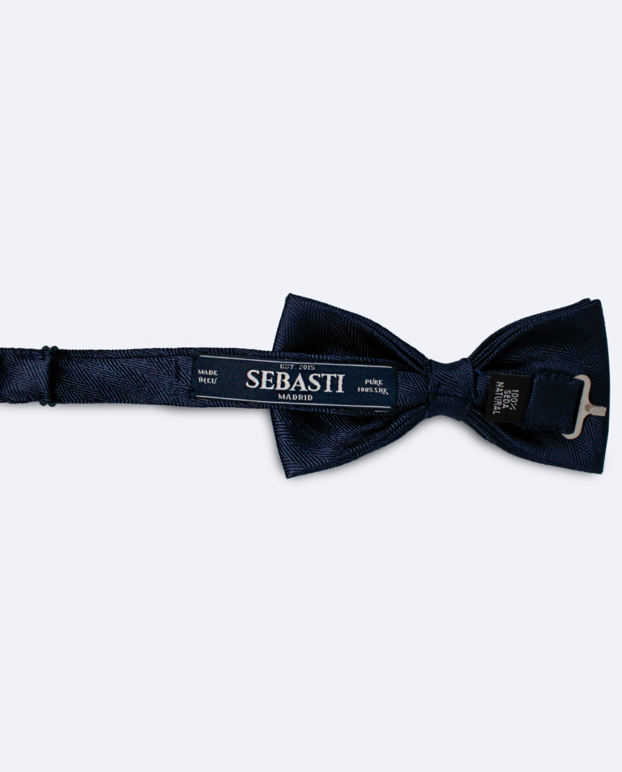 Vista trasera de la pajarita de seda espiga azul oscuro, con cinta ajustable y marca Sebasti en la etiqueta