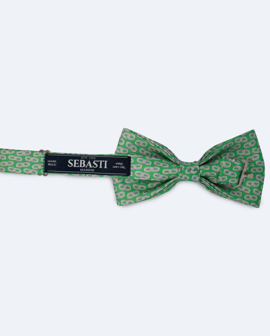 Vista trasera de la pajarita en seda verde claro con diseño de cadenas blancas, con cinta ajustable y marca Sebasti en la etiqueta