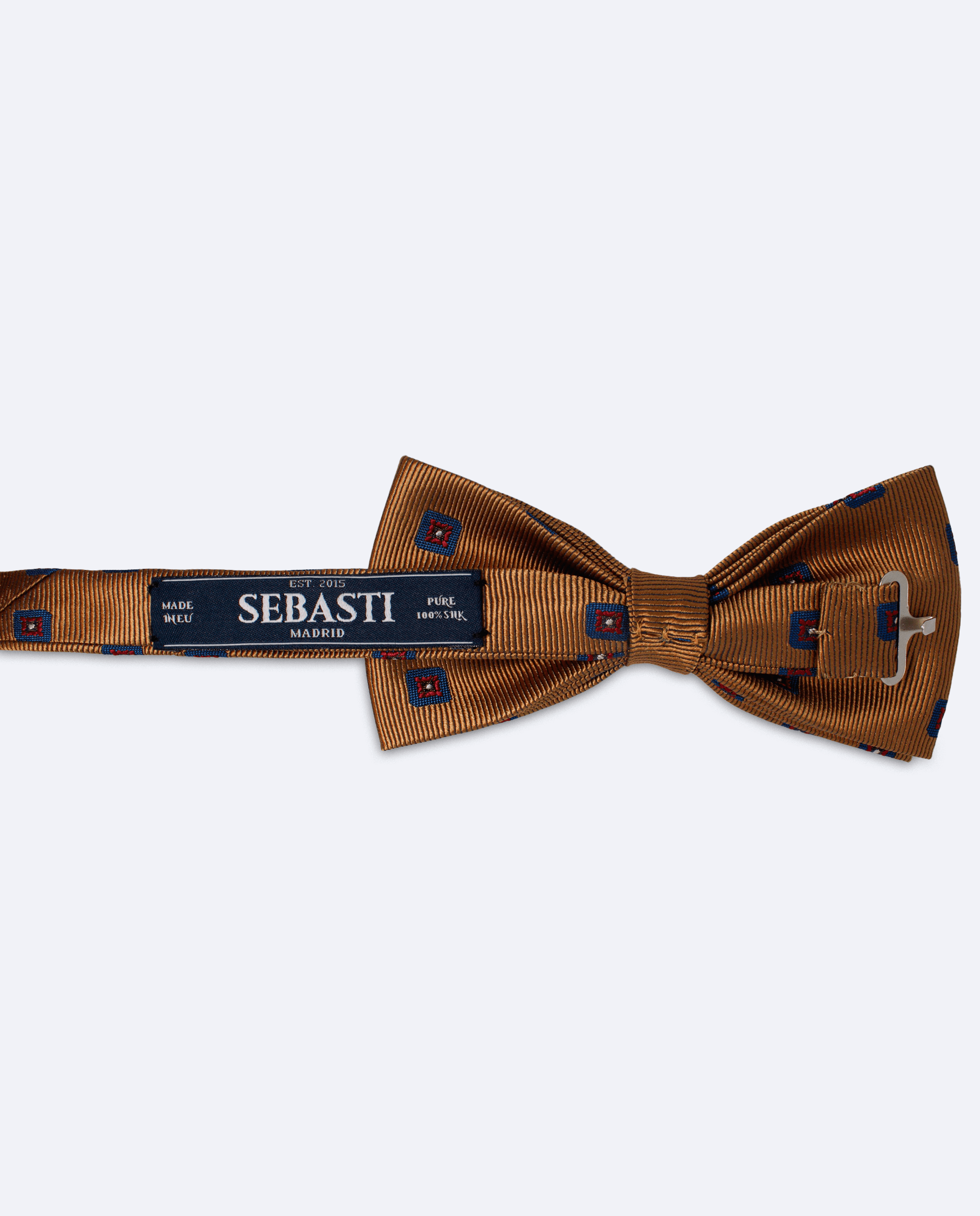 Vista trasera de la pajarita marrón claro con diseño de flores en seda satén. Incluye cinta ajustable y marca Sebasti en la etiqueta