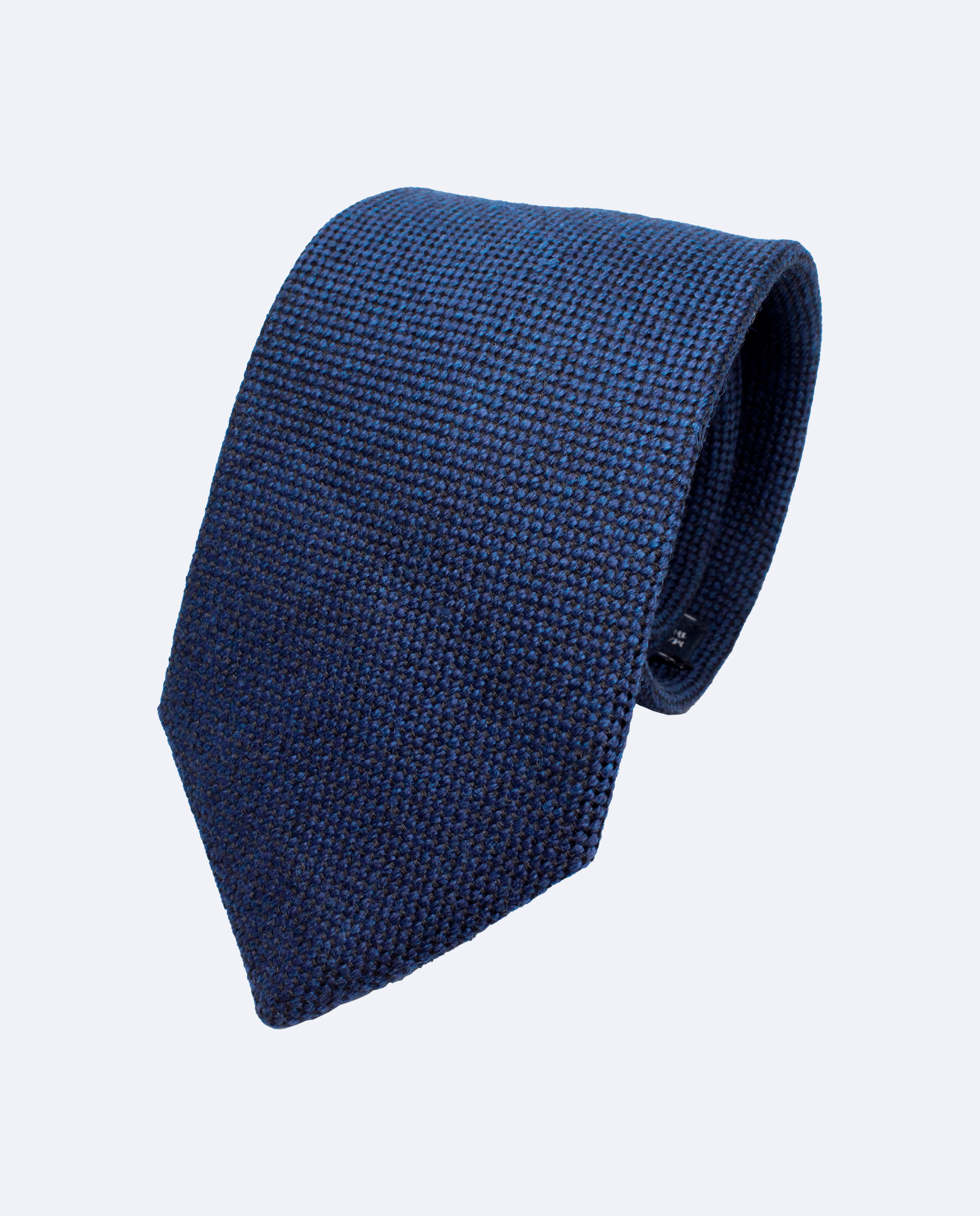 Corbata azul marino con tejido basket weave. Confeccionado en 100% lana italiana, vista enroscada