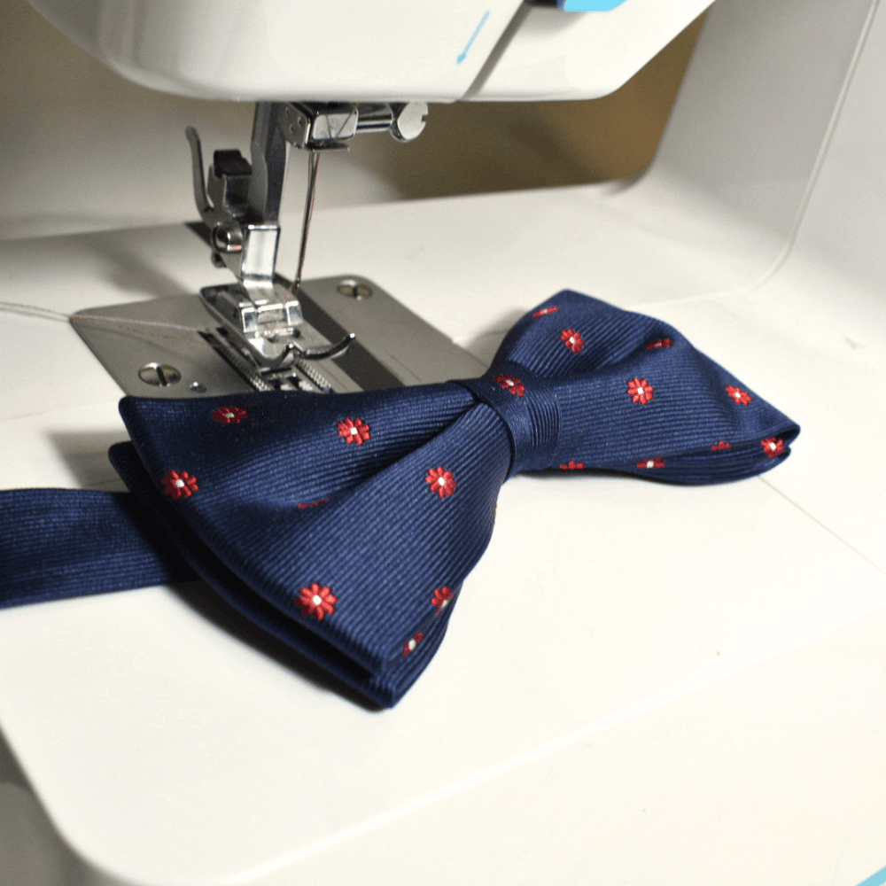 Pajarita azul sobre máquina de coser