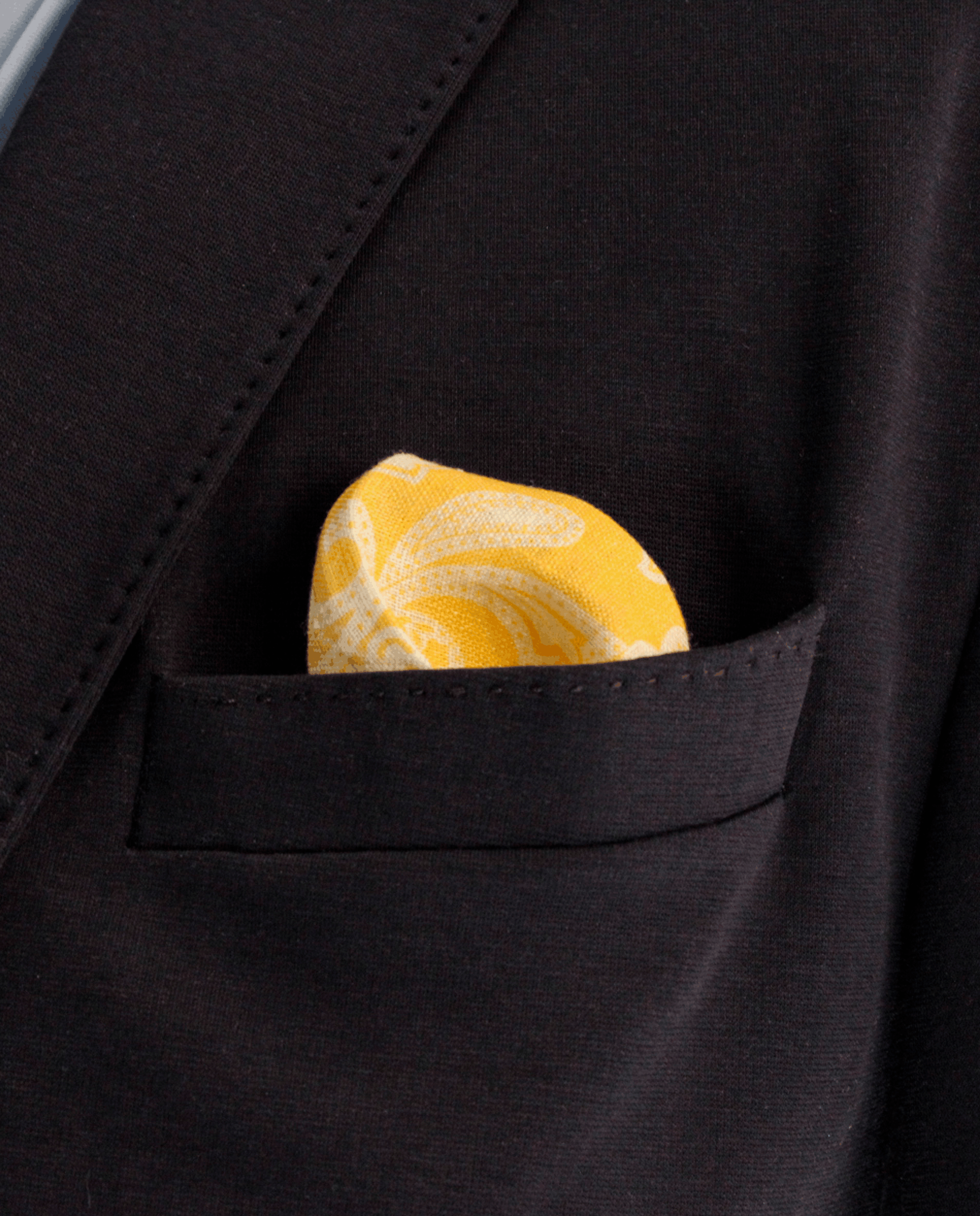 Pañuelo de bolsillo amarillo mostaza con cachemir blanco, colocado en el bolsillo de una americana | Sebasti