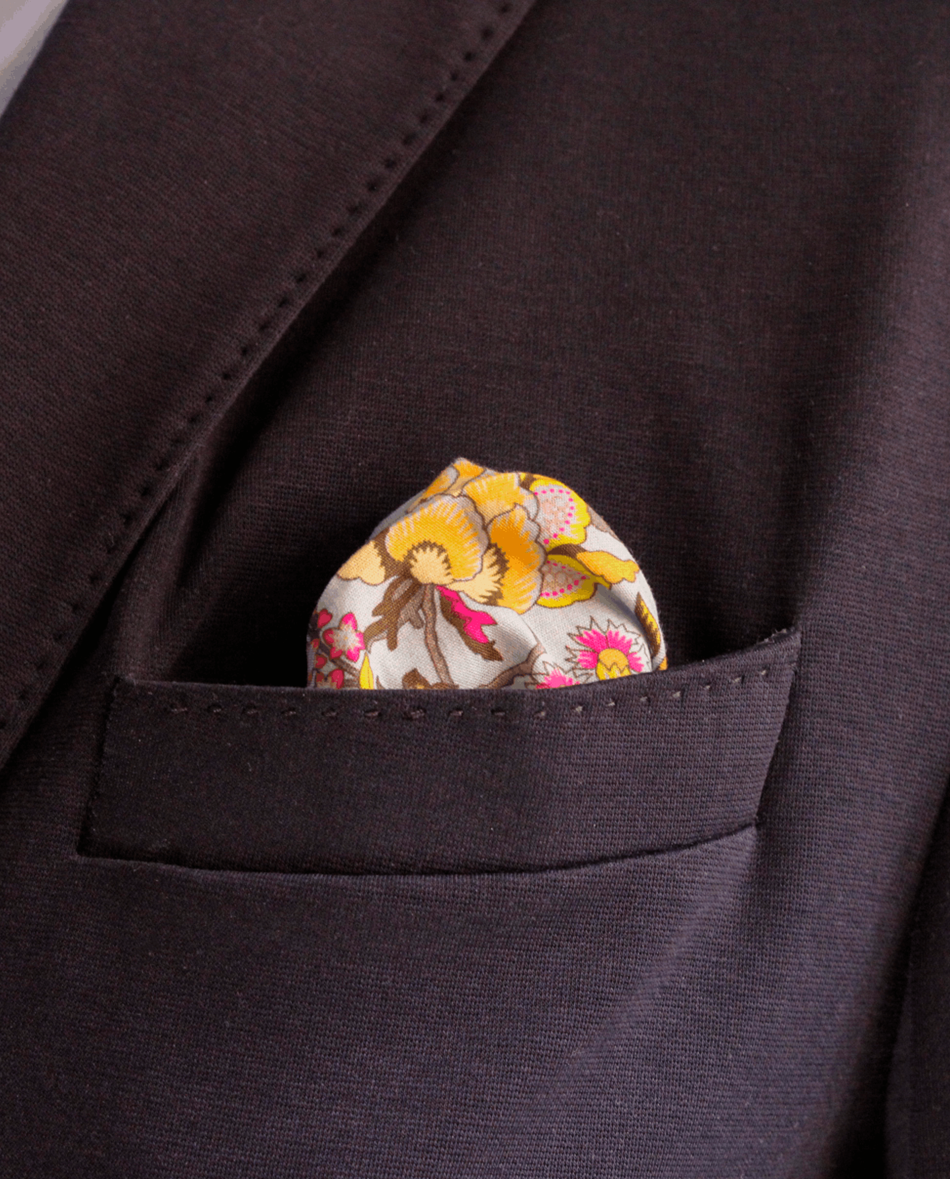 Pañuelo de bolsillo azul claro con flores multicolor, colocado en el bolsillo de una americana | Sebasti