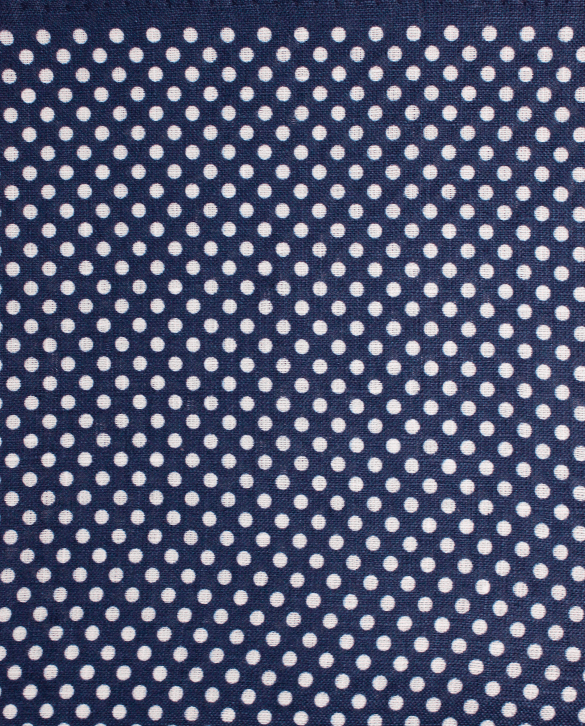 Pañuelo de bolsillo azul marino con lunares blancos, detalle de cerca del tejido y el estampado