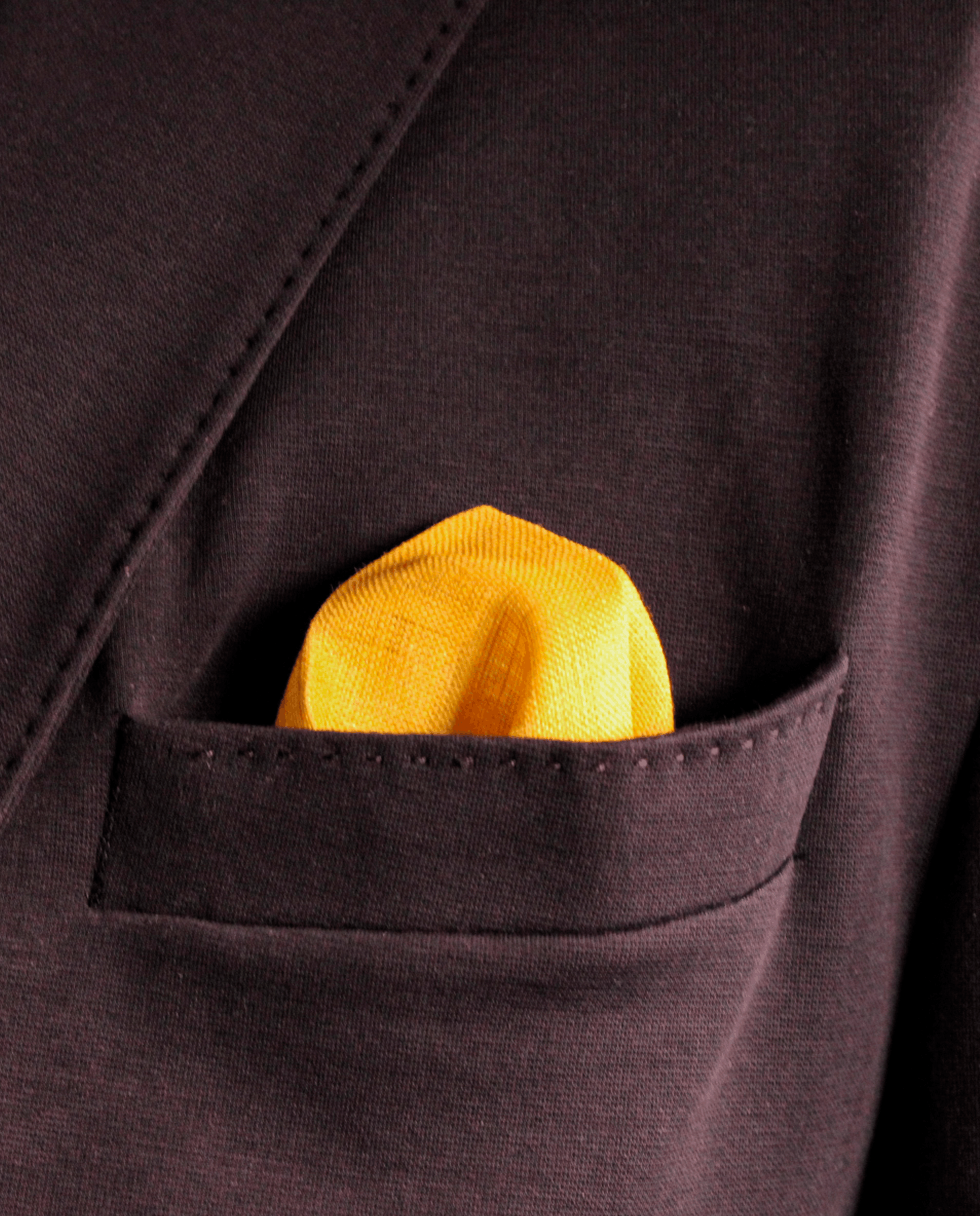 Pañuelo de bolsillo blanco y amarillo mostaza, colocado en el bolsillo de una americana | Sebasti