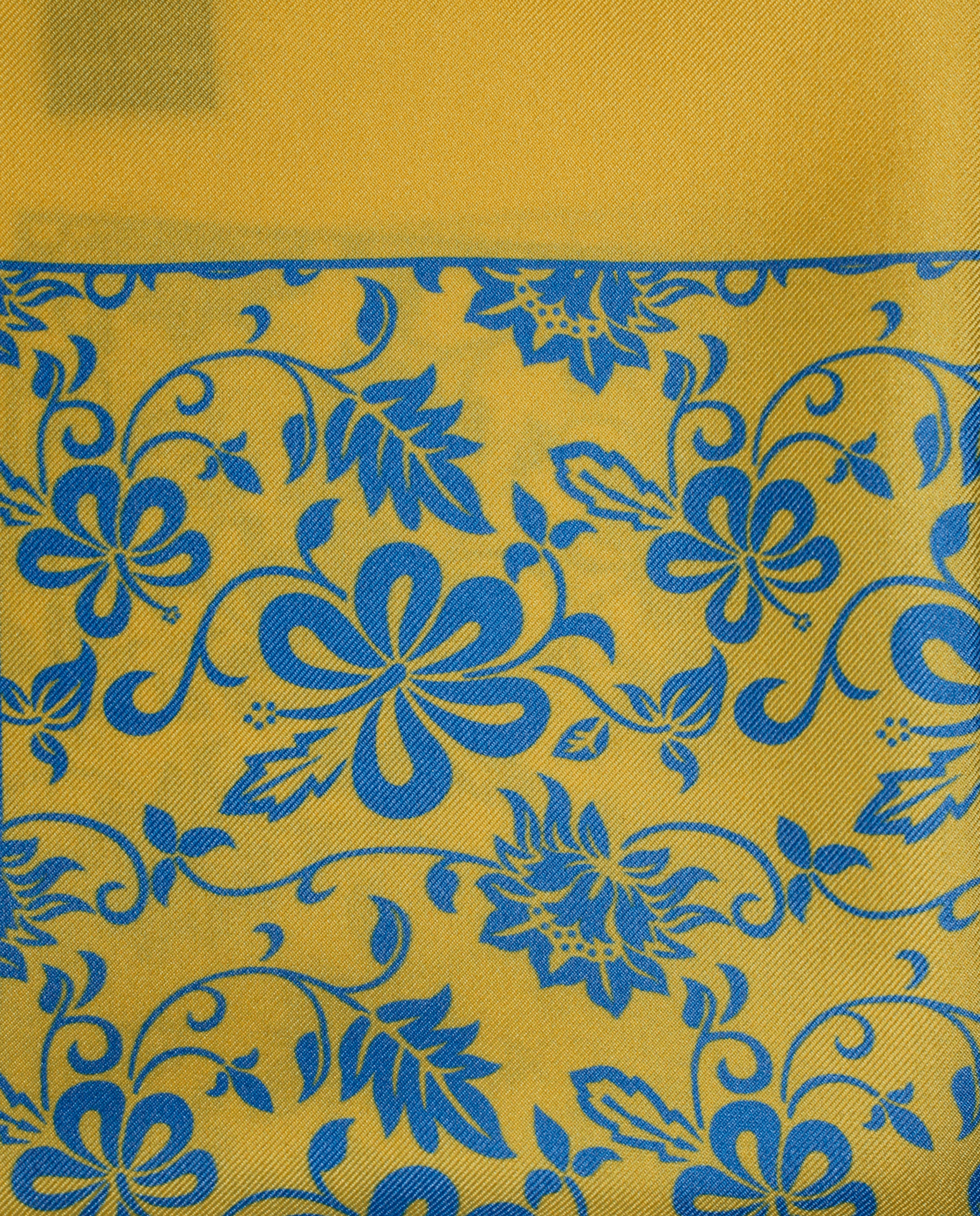 Pañuelo de bolsillo de seda amarillo con flores azules, detalle de cerca del tejido y el estampado