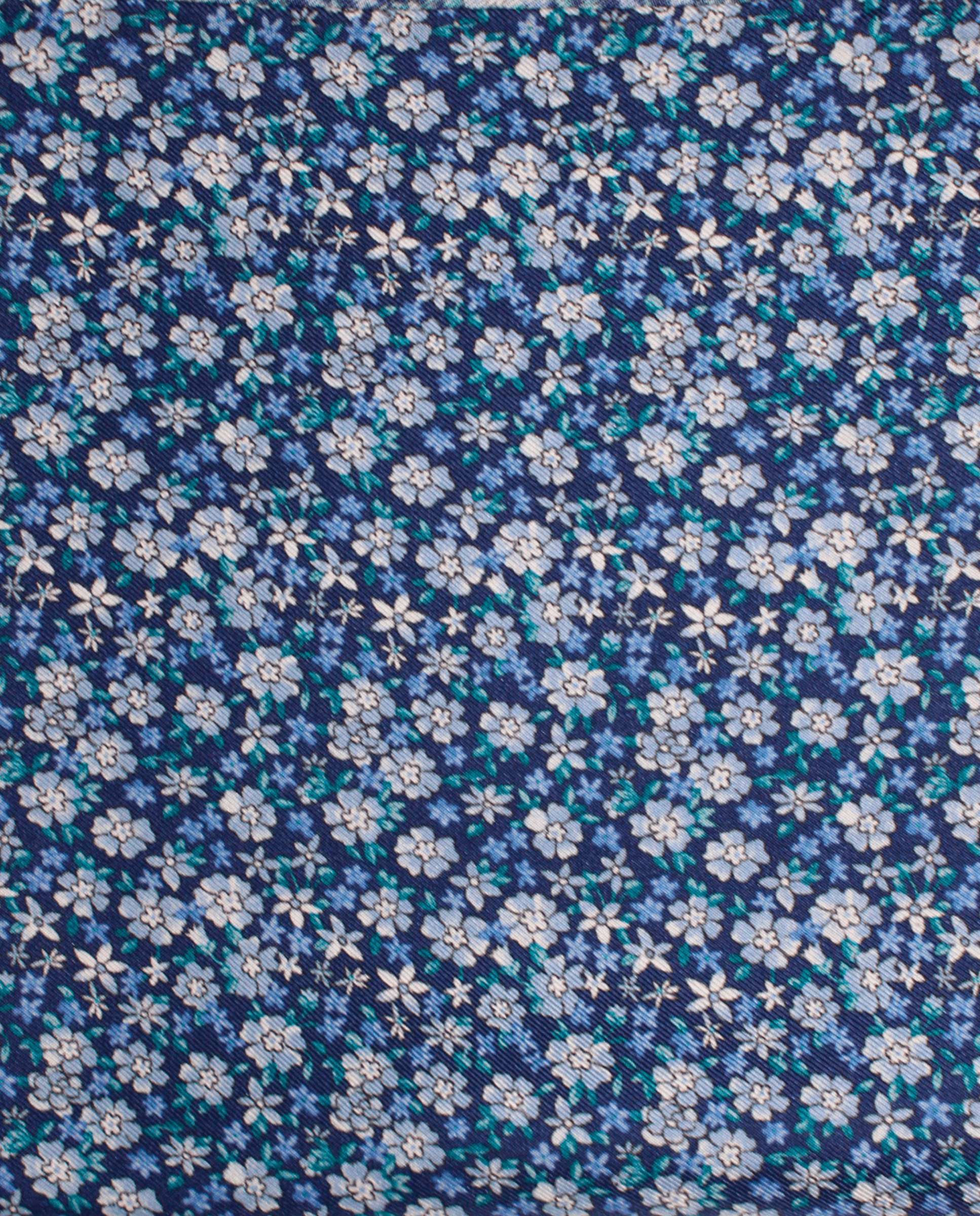Pañuelo de bolsillo de seda azul marino con flores liberty azul claro, detalle de cerca del tejido y el estampado