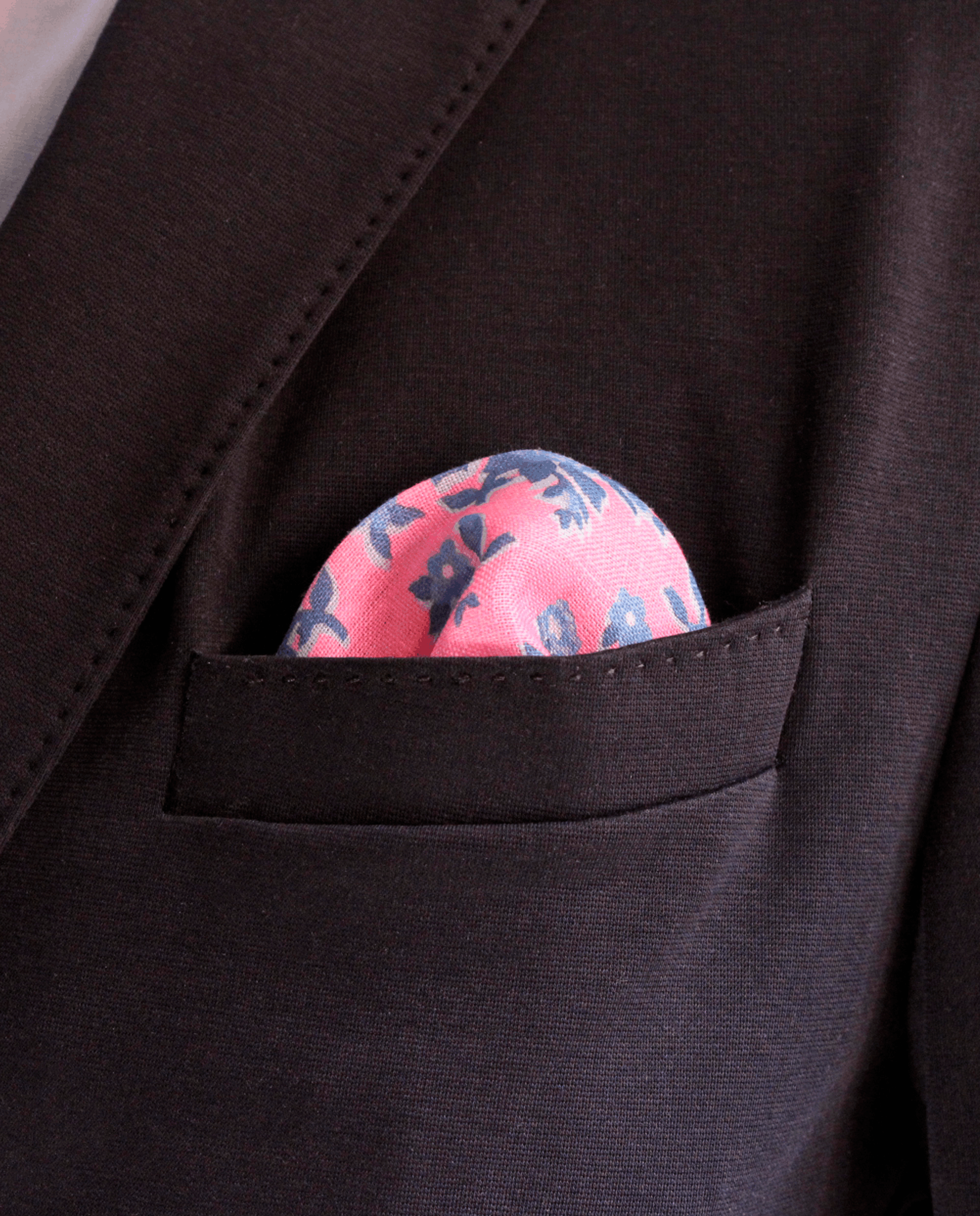 Pañuelo de bolsillo rosa con flores azules, colocado en el bolsillo de una americana | Sebasti