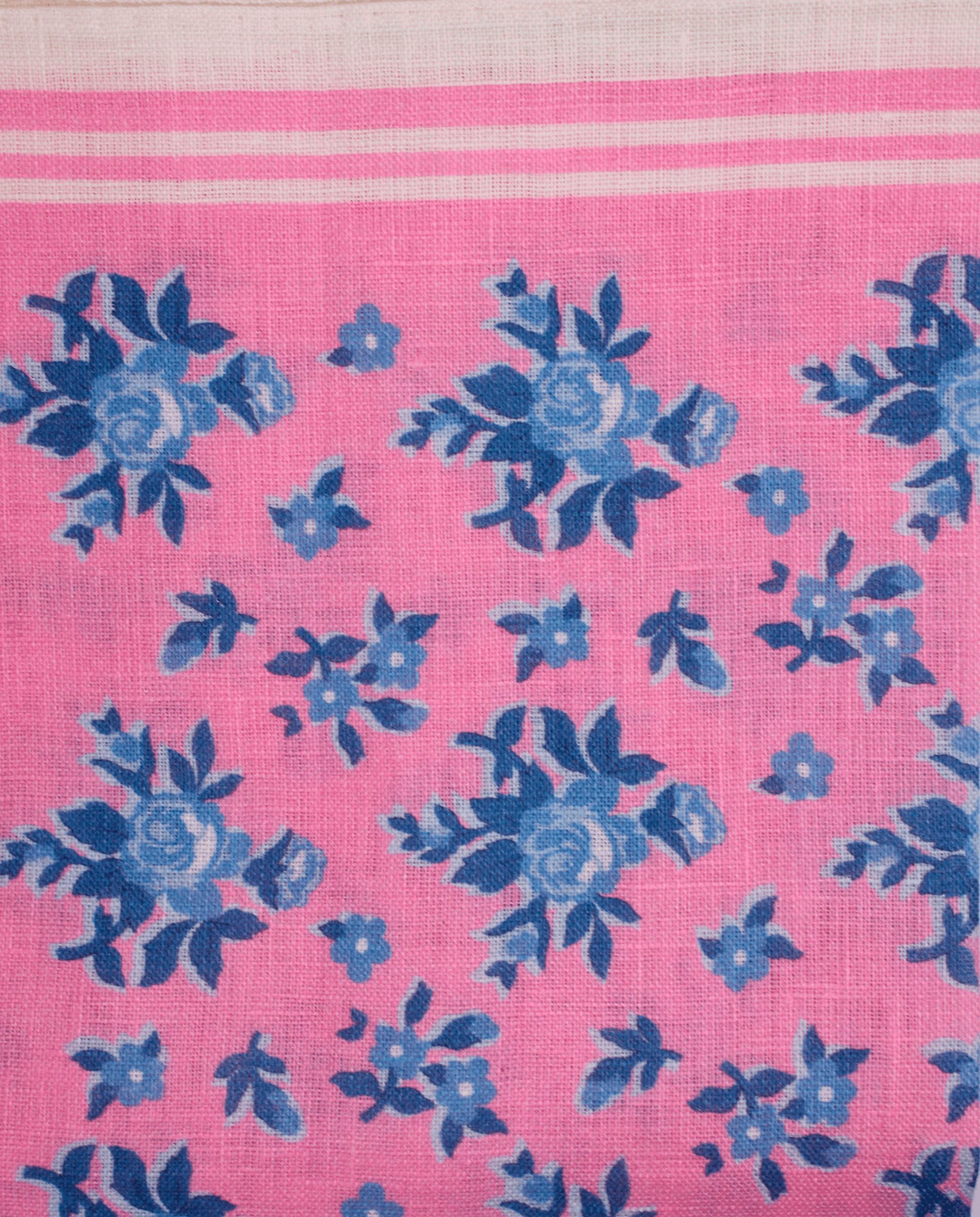 Pañuelo de bolsillo rosa con flores azules, detalle de cerca del tejido y el estampado